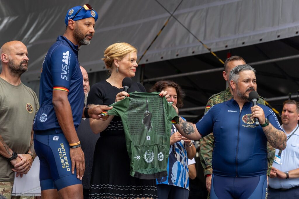 Bundestagspräsidentin Julia Klöckner begrüßt beim 1. Veteranentag am 15. Juni 2025 die “Battlefield Cyclists”, einen Zusammenschluss psychisch und physisch verwundeter Veteranen, auf der Bühne vor dem Deutschen Bundestag.