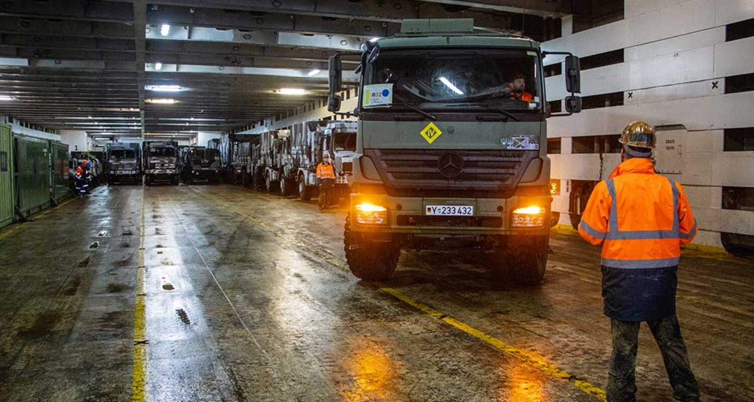 Ein Einweiser weist einen Kraftfahrer eines Lkw per Handzeichen in die Parkposition an Bord eines Roll-on-roll-off-Schiffes ein. (Foto © Bw/Michael In der Au)