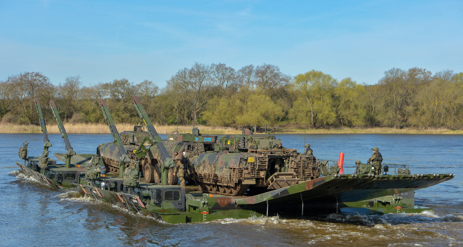 Gefechtsfahrzeuge vom Panzergrenadierbataillon 212 auf einer Fähre aus Amphibienfahrzeugen M3 vom Deutsch/Britischen
Pionierbrückenbataillon 130 über die Elbe während der Übung „Wettiner Schwert 2024“ im Rahmen der Übungsserie „Quadriga 2024 
(Foto © Bw/Carl Schulze)