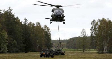Transporthubschrauber NH90 fliegt Geländefahrzeug als Außenlast in Landezone. (Foto © Bw/Andreas Bernstein)