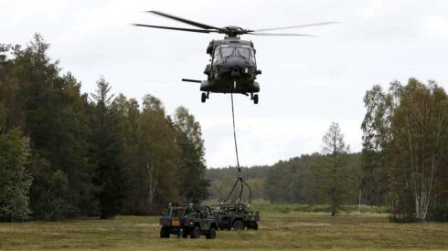 Transporthubschrauber NH90 fliegt Geländefahrzeug als Außenlast in Landezone. (Foto © Bw/Andreas Bernstein)