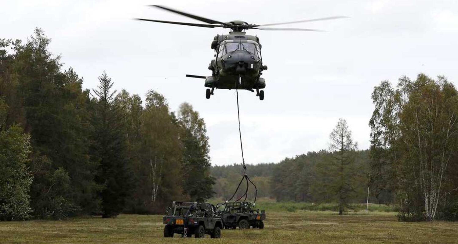 Transporthubschrauber NH90 fliegt Geländefahrzeug als Außenlast in Landezone. (Foto © Bw/Andreas Bernstein)