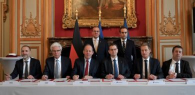 Vertreter von KNDS, Rheinmetall und Thales unterzeichnen den Gesellschaftervertrag der MGCS Project Company im Beisein des deutschen und französischen Verteidigungsministers (hinten).