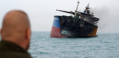 Einer von zwei Tankern, die über Nacht vermutlich mit Überwasser-Kamikazedrohnen angegriffen worden, liegt nach einem Feuer mit Schlagseite vor der irakischen Hafenstadt Basra.