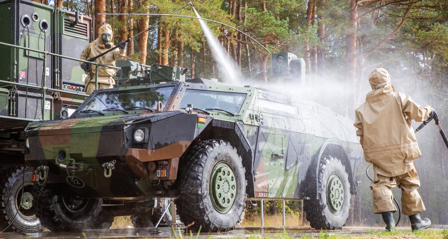 Dekontaminationskräfte bei der gründlichen Dekontamination eines Spähwagen Fennek. (Foto ©SABCAbw/GSchAufg)