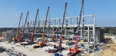 Maßarbeit: Sechs Kräne heben den zweiten Stahlträger der neuen Halle des A400M-Wartungszentrums in seine Position. (Foto © André Franzmann/Sellhorn)