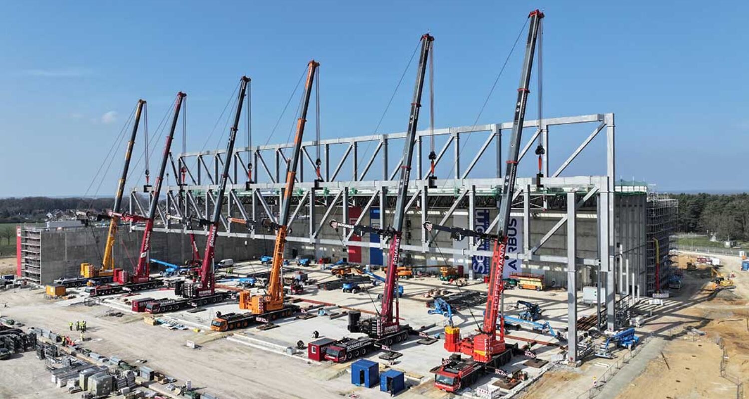 Maßarbeit: Sechs Kräne heben den zweiten Stahlträger der neuen Halle des A400M-Wartungszentrums in seine Position. (Foto © André Franzmann/Sellhorn)