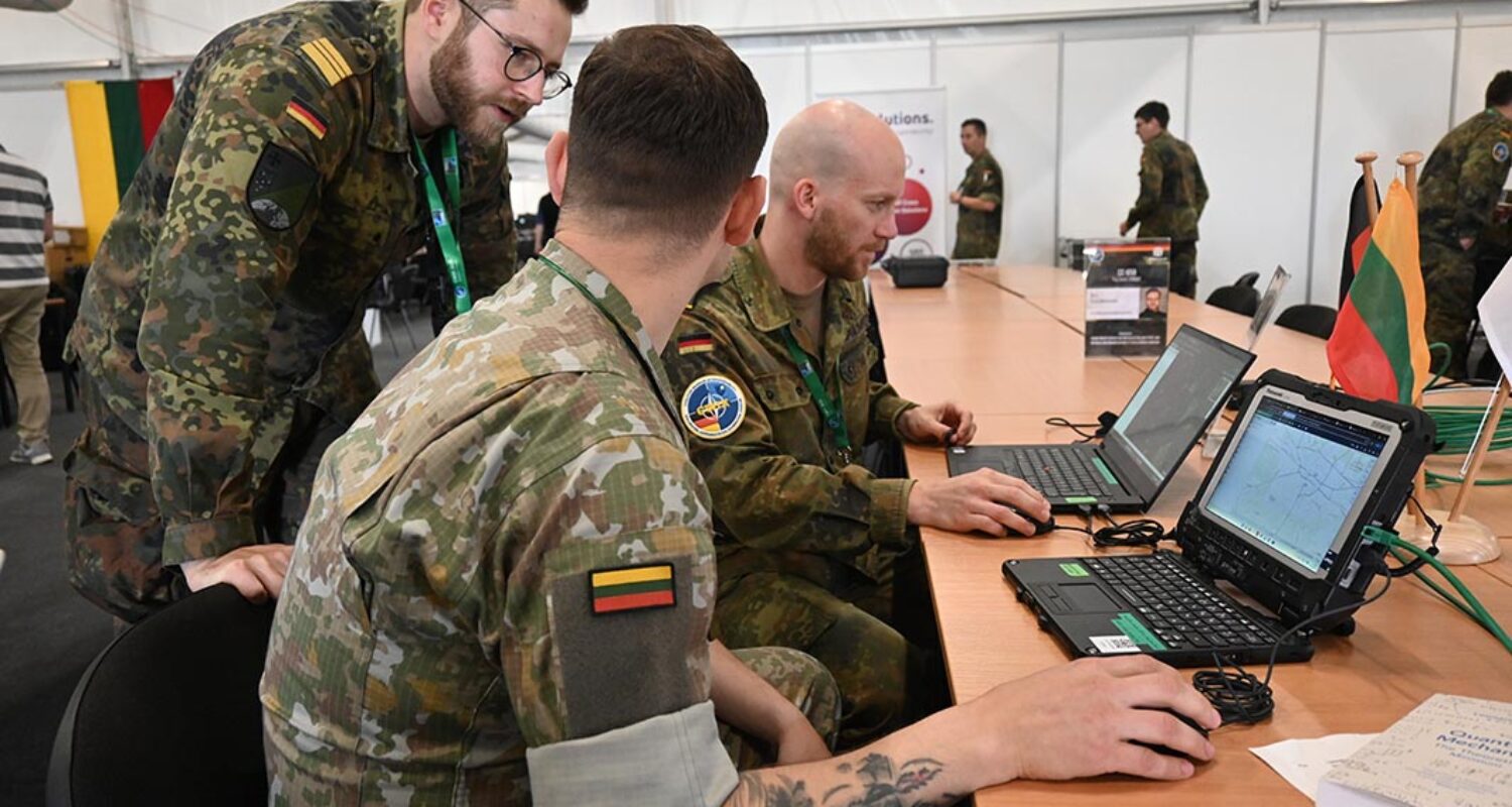 Das prototypisch aufgebaute Gesamtsystem wird halbjährlich durch Übungen verifiziert. Hierbei steht die internationale Zusammenarbeit im Vordergrund. Bei der diesjährigen CWIX weist Kapitänleutnant Hirschauer einen litauischen und deutschen Soldaten in die Nutzung ein. © Bundeswehr/Patrick Wohnlich