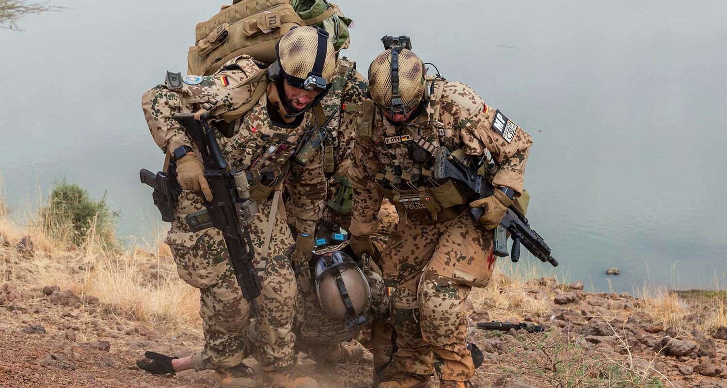 Soldaten bringen einen verletzten Kameraden aus der Gefahrenzone in einer gestellten Szene während einer Luftrettungsübung der Feldjäger im Rahmen der Mission MINUSMA in Gao/Mali. (Foto  © Bw/Meike Reetz)